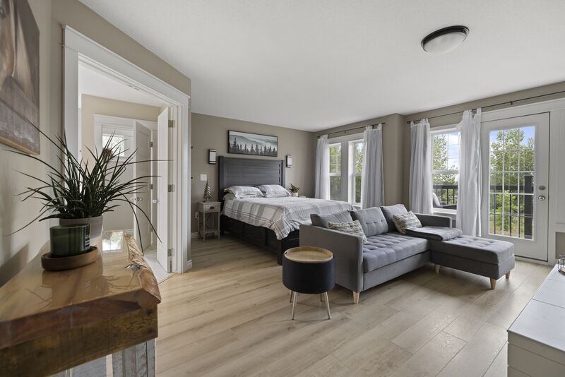 Primary bedroom with vaulted beam ceiling and large windows