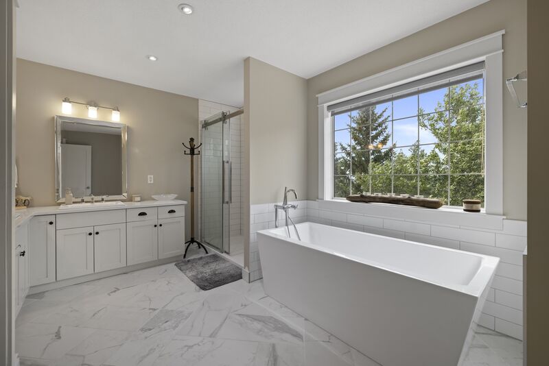 Primary ensuite bathroom with freestanding tub and glass shower
