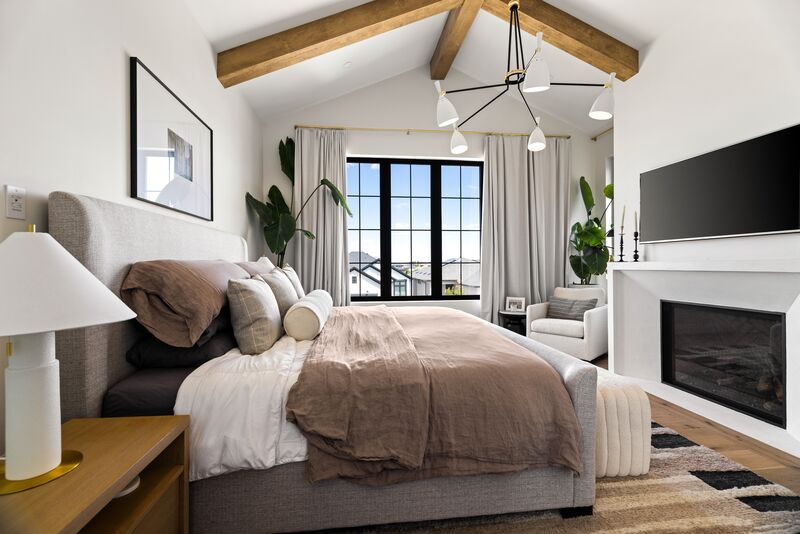 Primary bedroom with vaulted wood-beam ceiling and fireplace