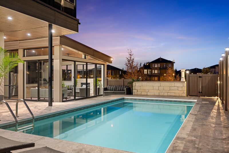 Pool at twilight with warm interior lighting